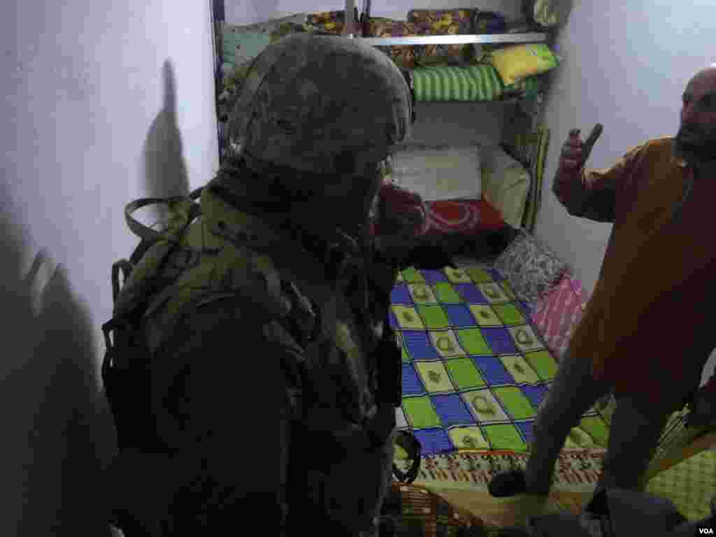 阿娅的叔叔阿亚迈德向伊拉克军人展示他们栖身的地下室。（美国之音希瑟&middot;默多克拍摄） &nbsp;