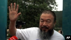 Dissident Chinese artist Ai Weiwei waves from the doorway of his studio after he was released on bail in Beijing, June 23, 2011. Ai was detained in April, igniting an international uproar.