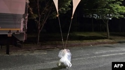 Esta foto tomada por el Ministerio de Defensa de Corea del Sur entre la noche del 28 al 29 de mayo de 2024 y publicada el 29 de mayo muestra objetos no identificados atados a globos en una calle de Chungnam.