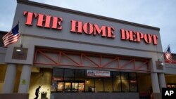 FILE - A passer-by, below left, walks toward an entrance to a Home Depot store in Boston, Jan. 27, 2020. Home Depot is among the 3,500 companies suing the Trump administration over tariffs on Chinese-made goods.