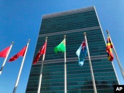 FILE - Flags fly outside the United Nations headquarters in New York.
