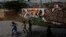 FILE - Children play soccer outside as they wait for the inauguration of a soccer pitch at the entrance of Jacarezinho shantytown in Rio de Janeiro, Brazil.