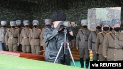 North Korean leader Kim Jong Un uses binoculars while attending a drill by a unit of the Korean People's Army, Feb. 29, 2020.