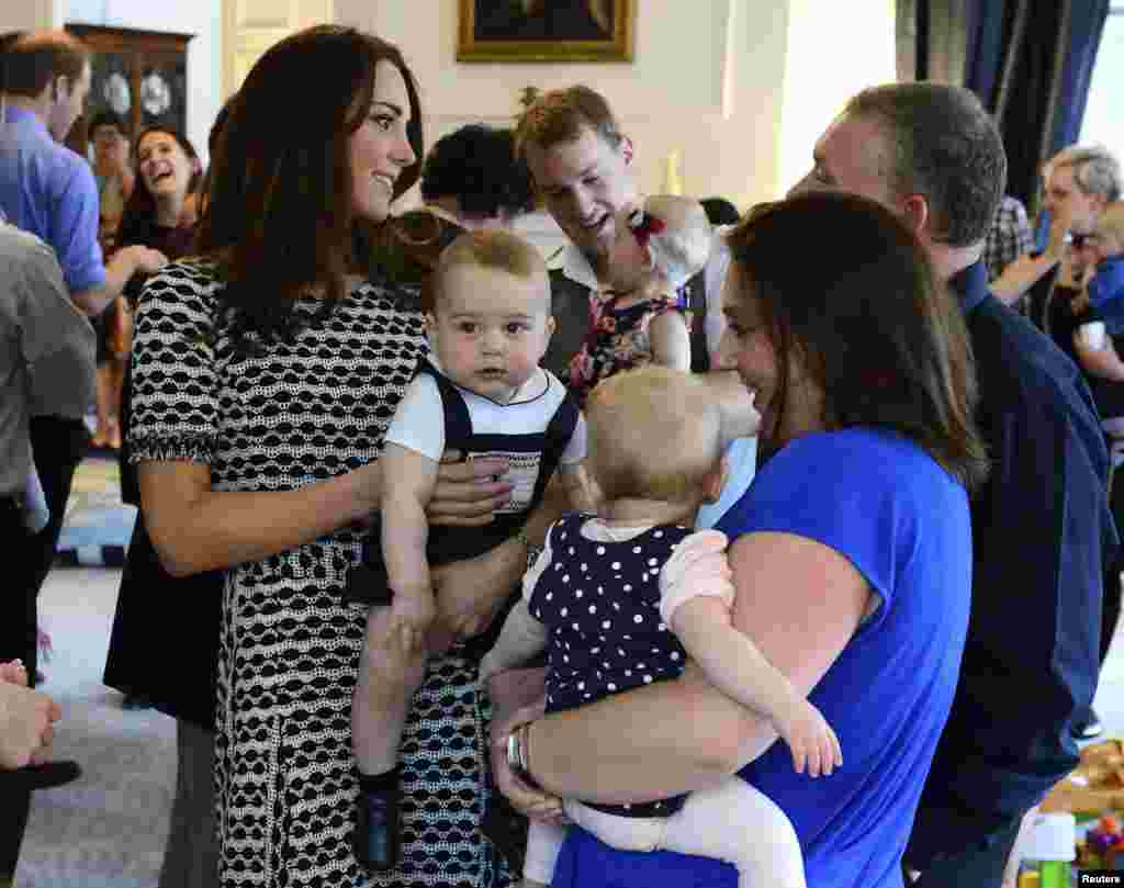 Britain&#39;s Catherine, Duchess of Cambridge, holds her son Prince George as she talks to other parents at a Plunket play group event at Government House in Wellington, New Zealand.