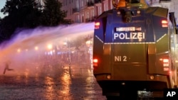 Protesters confront a police water cannon during anti G-20 demonstrations in Hamburg, Germany, July 8, 2017. 