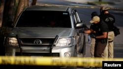 Police investigators work at a crime scene where the body of Panamanian honorary consul Carlos Armando Lemus was found in San Salvador, El Salvador, May 26, 2016.