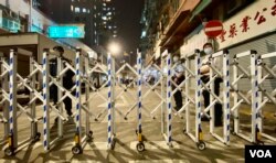 港府1月26日晚首次在油麻地碧街及东安街一带实施”突袭式”封区禁足强制检测，警方在现场看守，不让封锁区内的居民离开。 (美国之音/汤惠芸)