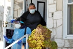Home care nurse Flora Ajayi is thanked by a clients daughter as she departs from a home while wearing personal protective equipment (PPE) to protect herself and prevent cross-contamination while visiting a client, April 22, 2020.