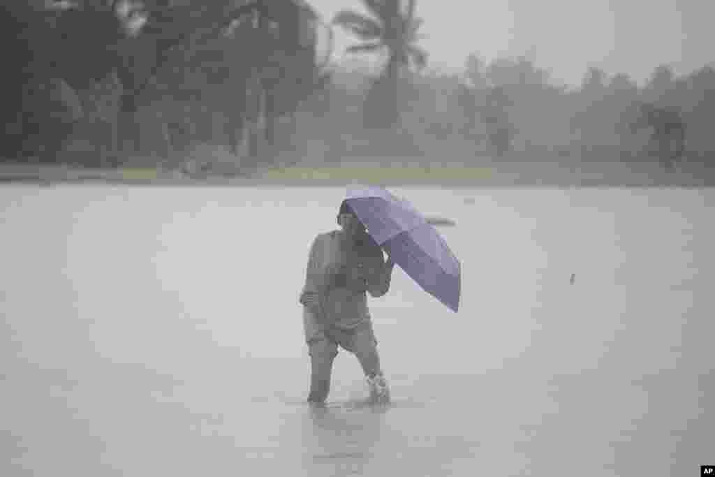 A man crosses a flooded rice field during rains after Tropical Storm Trami, locally named Kristine, dumped heavy rains at Libon town, Albay province, Philippines.