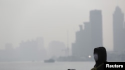 在上海空气污染严重的一天，民众带着防护口罩游览外滩