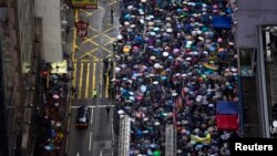 Pro-democracy protesters march in the streets to demand universal suffrage and urge Hong Kong's Chief Executive Leung Chun-ying to step down in Hong Kong, July 1, 2013. 