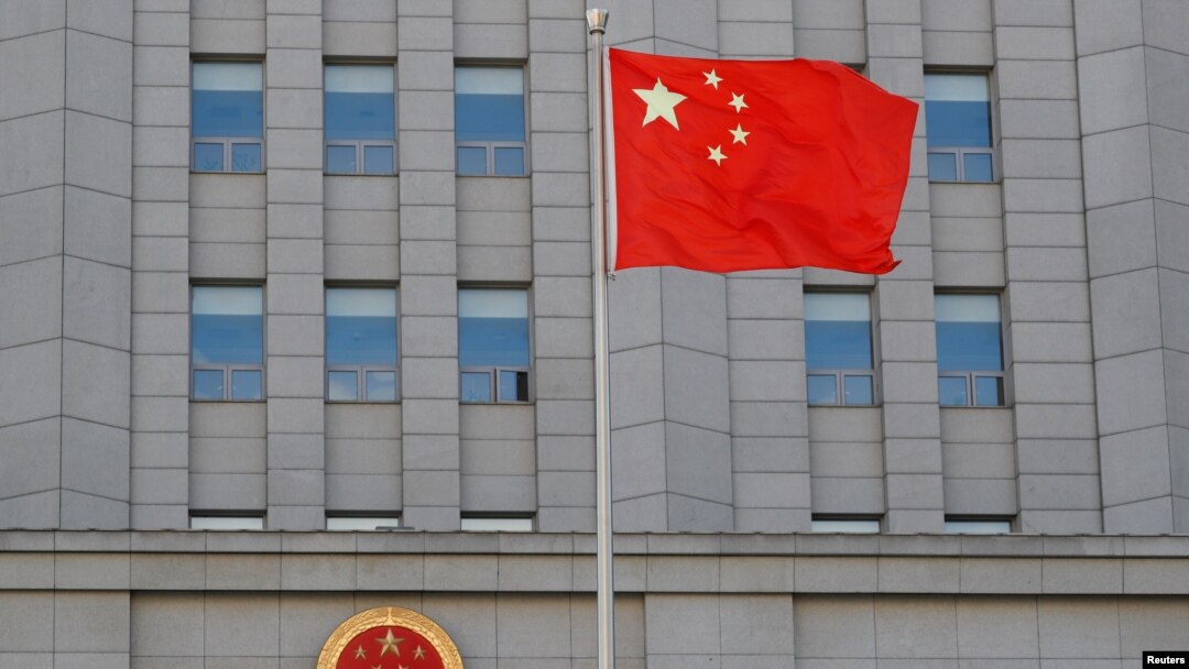 Sebuah bendera China berkibar di dekat lambang nasional China di Pengadilan Menengah Rakyat No. 2 Beijing, 11 September 2020. (Foto: Reuters)