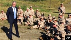 FILE - Defense Secretary Jim Mattis talks to U.S. Marines at a rifle range at Guantanamo Bay, Cuba, Dec. 21. 2017. The unannounced visit was the first by a defense secretary since Donald Rumsfeld visited in January 2002 shortly after the first prisoners arrived from Afghanistan. 