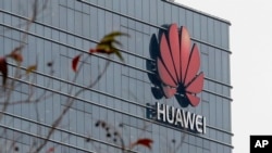 FILE - A logo of Huawei marks one of the company's buildings in Dongguan, in China's Guangdong province, March 6, 2019.