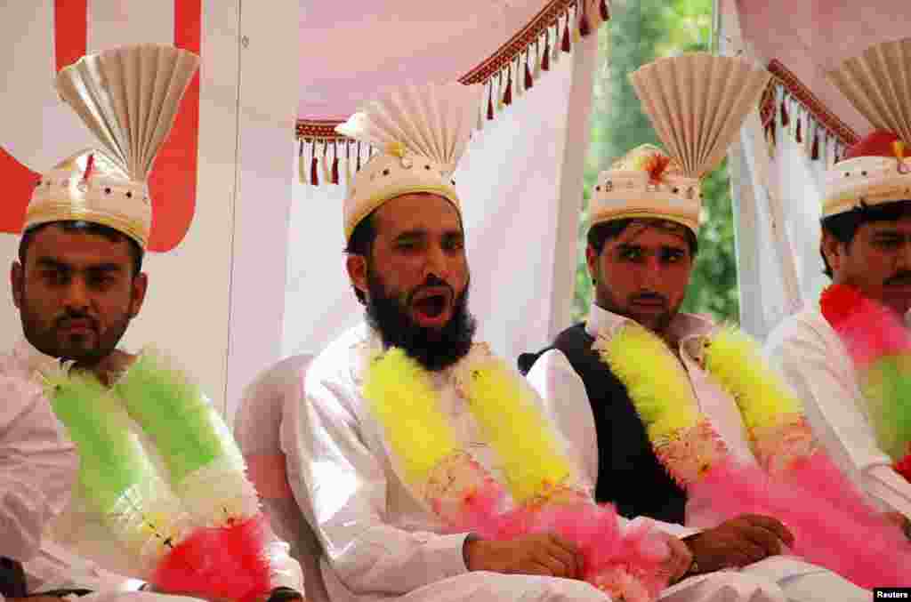 A groom yawns as he sits with others during a mass wedding ceremony in Peshawar, Pakistan.