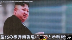 Seorang pria mengambil foto sebuah program berita televisi yang menampilkan gambar Pemimpin Korea Utara Kim Jong Un, di Tokyo, Jepang, 6 Agustus 2017.