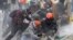Des manifestants antigouvernementaux se mettent à l'abri d'un canon à eau de la police lors d'affrontements à Madrid, à la périphérie de Bogota, en Colombie, le 28 mai 2021.