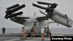 在美海军第三舰队主导的一次军演中，海军陆战队员检查一架降落在日本海上自卫队直升机驱逐舰的鱼鹰战机。