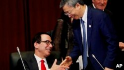 美财政部长姆奴钦6月8日在日本20国集团财长会议上与中国央行行长易纲握手。