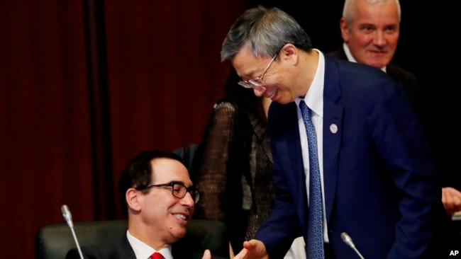 美国财政部长姆努钦与中国银行行长易纲星期六(2019年6月8日)在日本20国财长与央行行长会议期间握手。