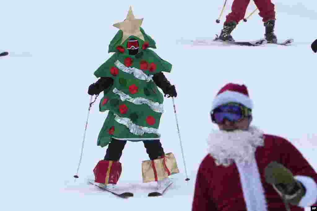 A skier dressed as a Christmas tree skis for charity at the Sunday River Ski Resort, Dec. 11, 2022, in Newry, Maine.&nbsp;