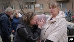 Мешканці Печерського району біля зони, яка постраждала від російського ракетного удару по Києву у понеділок, 25 березня 2024 року. П’ятеро людей отримали поранення, двох госпіталізовано. (Фото: AP Photo/Vadim Ghirda)