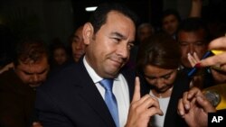 Jimmy Morales, the National Front of Convergence party presidential candidate, talks with reporters upon his arrival to the Electoral Supreme Court headquarters in Guatemala City, Sunday, Oct. 25, 2015.