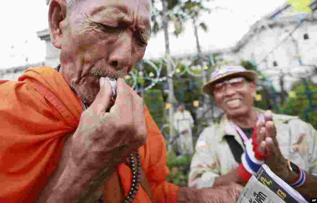 Mtawa wa ki-Budha akipiga firimbi wakati wa mkutano wa hadhara nje wa wizara ya mambo ya ndani mjini Bankok Bangkok, Nov. 26, 2013. 
