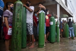 Relatives of COVID-19 patients queue for long hours to refill their oxygen tanks in Manaus, Amazonas state, on January 19, 2021. (AFP)