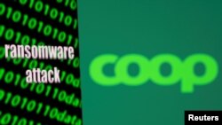 Sebuah smartphone dengan layar yang bertuliskan "serangan ransomware" dan kode biner ditampilkan di depan logo Coop dalam foto ilustrasi yang diambil pada 6 Juli 2021. (Foto: Reuters/Dado Ruvic) 