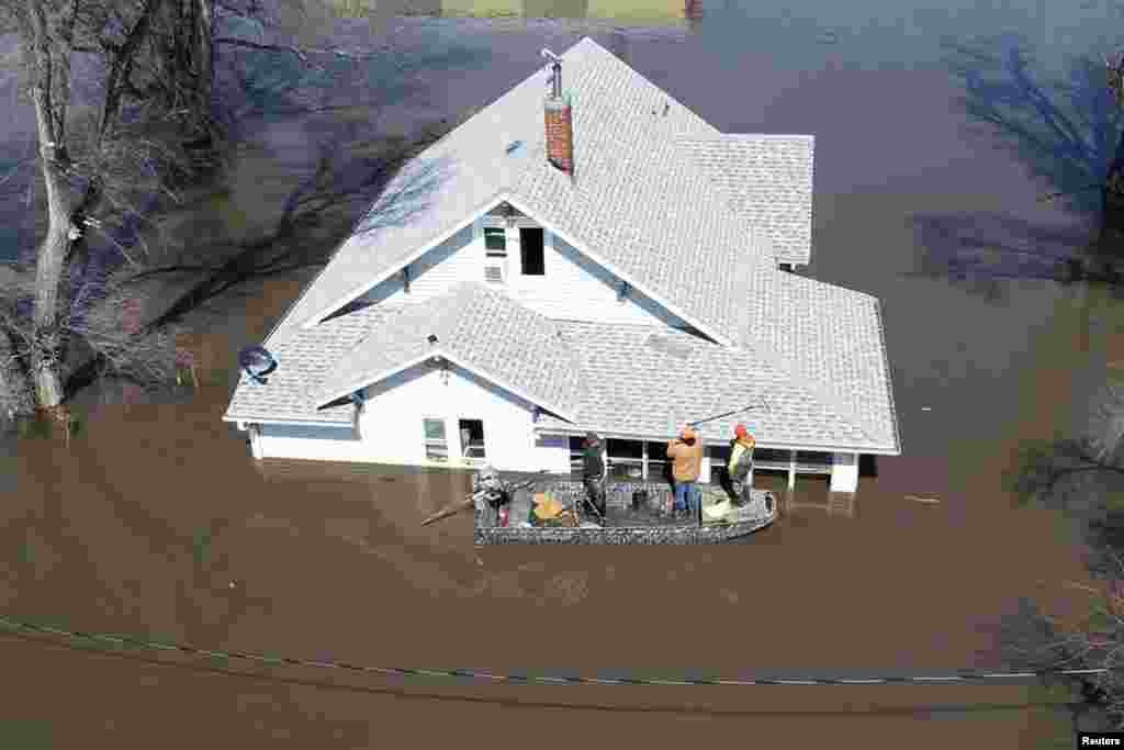 Lanni Bailey and a team from Muddy Paws Second Chance Rescue enter a flooded house to pull out several cats during the flooding of the Missouri River near Glenwood, Iowa, U.S., March 18, 2019.