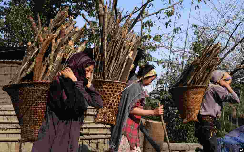 Naga women carry firewood as they walk home from a day in the field near Viswema village, in the northeastern Indian state of Nagaland.