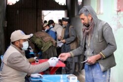 Warga Afghanistan antre makanan yang diselenggarakan oleh Program Pangan Dunia (WFP) di Pul-e-Alam, ibu kota provinsi Logar. timur Afghanistan, Selasa, 18 Januari 2022. (AP)