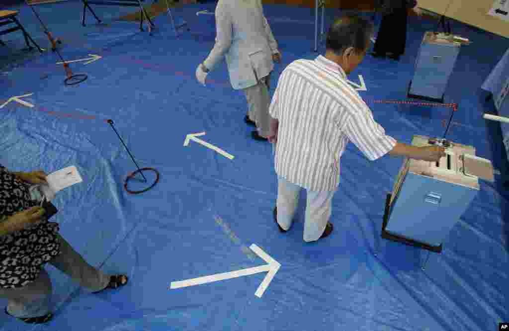 An elderly man casts his vote in Japan's upper house parliamentary elections at a polling station in Tokyo, July 21, 2013. 