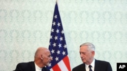 Prezidan afgan an, Ashraf Ghani, agoch ak sekrete defans ameriken an Jim Mattis nan Afganistan pandan yon konferas de près. 