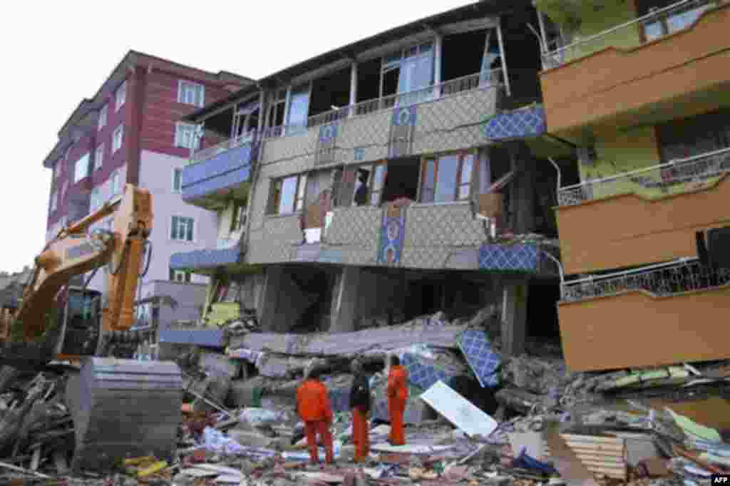 In this Wednesday, Oct. 26, 2011 photo, rescue workers examine the quake-toppled multistory Buse Cafe, center, in the worst-hit town of Ercis in Van province, Turkey. The magnitude-7.2 quake that struck Oct. 23 has killed more than 600 people, including 6