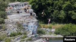 People jump into the Ottawa River on a hot summer day in Gatineau, Quebec, Canada, Aug. 10, 2016. 