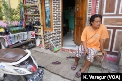 Community organizer Gugun Muhammad sits outside a sustainable pilot house in Kampung Tongkol, Indonesia.