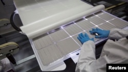 资料照：2018 年 1 月 15 日，一名生产操作员在俄勒冈州希尔斯伯勒的太阳能世界( SolarWorld) 的太阳能电池板工厂检查电池板。（路透社）