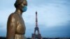 Zlatna statua sa zaštitnom maskom na licu na Trgu Trokadero, u blizini Ajfelove kule u Parizu (Foto: Reuters/Benoit Tessier)