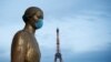 La estatua de oro en la plaza Trocadero, cerca de la torre Eiffel, usa una máscara protectora durante el brote de la enfermedad por coronavirus (COVID-19) en París, Francia.