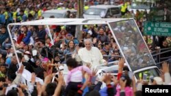 Pope Francis greets the crowd of faithful from a popemobile in Quito, Ecuador, July 5, 2015. 