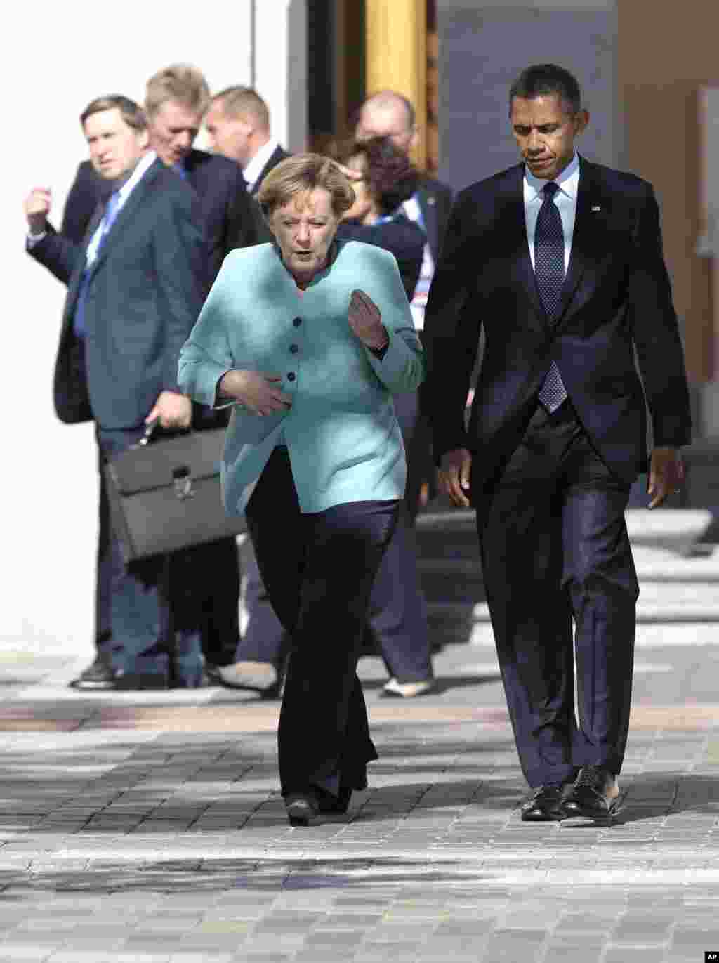 U.S. President Barack Obama, right, walks with Germany&#39;s Chancellor Angela Merkel prior to a group photo of G-20 leaders outside of the Konstantin Palace in St. Petersburg, Russia, Sept. 6, 2013.&nbsp;