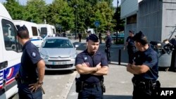 French policemen stand next to a police station on July 20, 2013, in Trappes, a suburb of Paris.