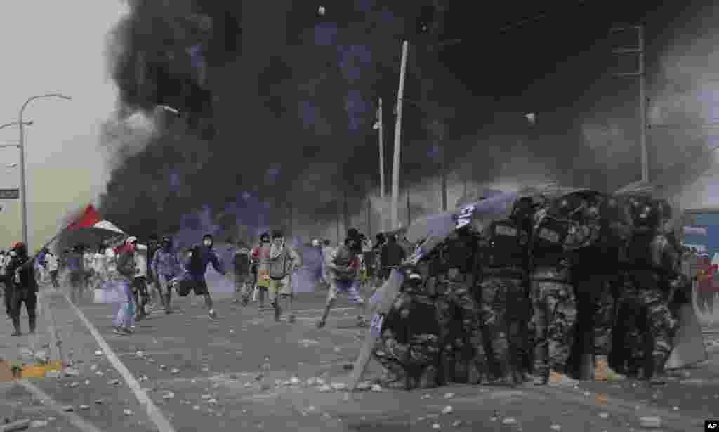 Farmworkers throw rocks at police on the Pan-American South Highway as they protest the Agricultural Promotion Law in the Barrio Chino neighborhood of Peru&#39;s Ica province, Dec. 22, 2020.
