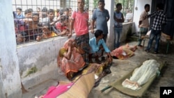 An elderly woman grieves next dead bodies at Mymensingh Medical College Hospital in the town of Mymensingh, Bangladesh, July 10, 2015. 