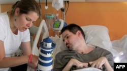 A handout photo taken on Sept. 28, 2014 by the parents of Vincent Lambert (R) and released by their lawyer Jean Paillot shows Vincent Lambert, a quadriplegic man on artificial life support, with his sister Marie Lambert (L) at a hospital in Reims. 