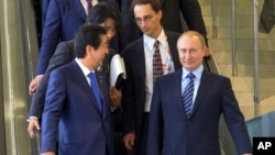 Japanese Prime Minister Shinzo Abe, left, and Russian President Vladimir Putin talk in Vladivostok, Russia, Friday, September 2, 2016.