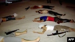 An image grab taken from a broadcast on Syrian television on July 20, 2012, shows dead men lying on the ground next to weapons in the Teshrin neighborhood of the Qabun area in Damascus. (AFP Photo / Ho / Shaam News Network)