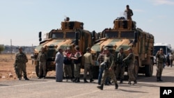 지난 29일 터키-시리아 국경 지역에서 터키군 병사들이 쿠르드계 터키 주민들과 대화하고 있다.